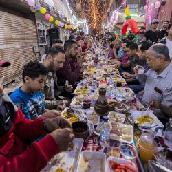 Musulmanes se reúnen a lo largo de una mesa en la calle para romper su ayuno de Ramadán juntos en una comida masiva "iftar" en el 15º día del mes sagrado musulmán, en el suburbio de Matariya en el noreste de la capital de Egipto, El Cairo. | Foto:KHALED DESOUKI / AFP