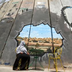 Una mujer palestina observa un mural que representa el complejo de la mezquita de Al-Aqsa y la ciudad vieja de Jerusalén en la controvertida barrera de separación de Israel entre Jerusalén y la Cisjordania ocupada, en Belén. | Foto:HAZEM BADER / AFP