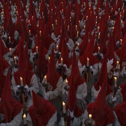 Penitentes miembros de la Real Hermandad del Santísimo Cristo de las Injurias sostienen velas mientras se reúnen cerca de la catedral antes de participar en la procesión del "Silencio" en el noroeste de España. | Foto:CESAR MANSO / AFP