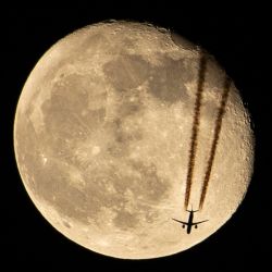Un avión sobrevuela la ciudad de Basora, en el sur de Irak, junto a la luna menguante. | Foto:HUSSEIN FALEH / AFP