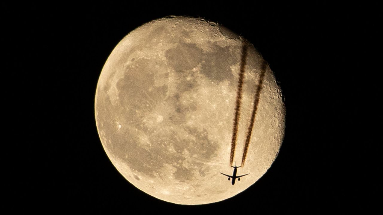 Un avión sobrevuela la ciudad de Basora, en el sur de Irak, junto a la luna menguante. | Foto:HUSSEIN FALEH / AFP