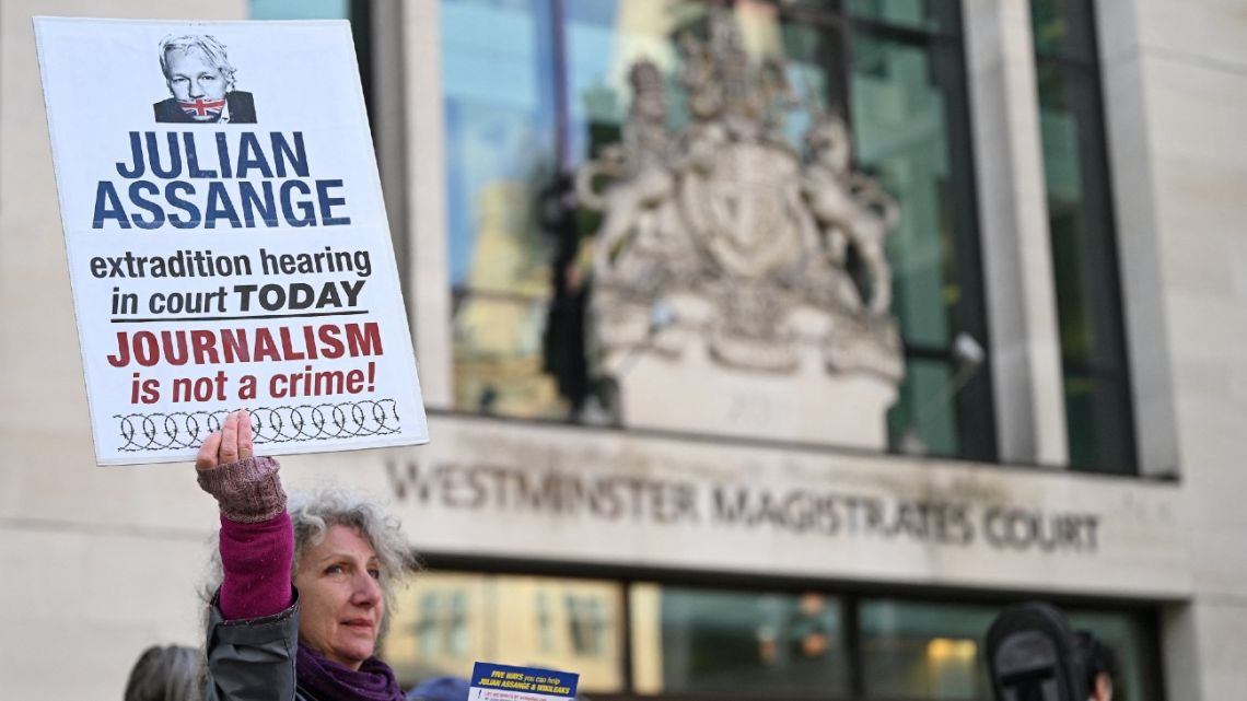 Supporters and activists hold placards outside Westminster Magistrates court in London on April 20, 2022, calling for WikiLeaks founder Julian Assange, who is currently in custody pending an extradition request from the US, to be freed. 
