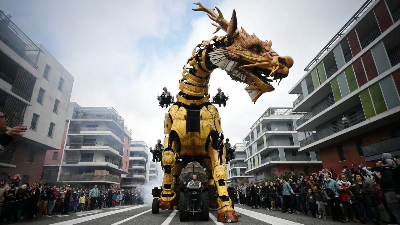 Operadores conducen el caballo-dragón llamado Long-Ma, creado por Francois de la Roziere y su compañía "La Machine", en las calles de Toulouse, sur de Francia. | Foto:VALENTINE CHAPUIS / AFP