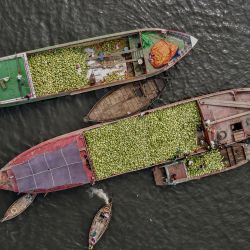 Esta foto aérea muestra a trabajadores descargando sandías de un buque de carga a un barco más pequeño en el río Buriganga en Dhaka, Bangladesh. | Foto:MUNIR UZ ZAMAN / AFP