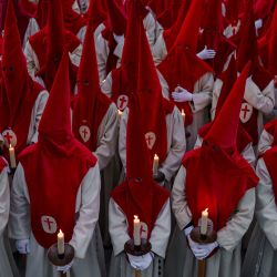 Penitentes miembros de la Real Hermandad del Santísimo Cristo de las Injurias sostienen velas mientras se reúnen cerca de la catedral antes de participar en la procesión del "Silencio" en la ciudad de Zamora, al noroeste de España. | Foto:CESAR MANSO / AFP