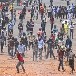Estudiantes de la universidad de Dhaka lanzan piedras durante un enfrentamiento con los comerciantes del Nuevo Mercado en Dhaka, Bangladesh. | Foto:MUNIR UZ ZAMAN / AFP