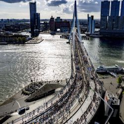 Corredores participan en la 41ª edición del Maratón de Rotterdam mientras cruzan el puente Erasmus en Rotterdam, Países Bajos. | Foto:ROBIN UTRECHT / ANP / AFP