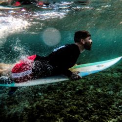 El surfista cubano Alejandro Pino se sumerge bajo una ola en la costa de La Habana. - Cuando eran niños, los surfistas cubanos transformaban sus pupitres de la escuela en tablas para surcar las olas. | Foto:YAMIL LAGE / AFP