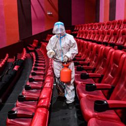 Un miembro del personal rocía desinfectante en un cine mientras la ciudad comienza a reabrir tras un brote de coronavirus Covid-19 en Shenyang, en la provincia nororiental china de Liaoning. | Foto:AFP
