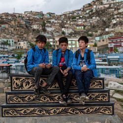 Unos alumnos charlan entre ellos mientras visitan el cementerio Kart-e-Sakhi en Kabul, Afganistán. | Foto:WAKIL KOHSAR / AFP