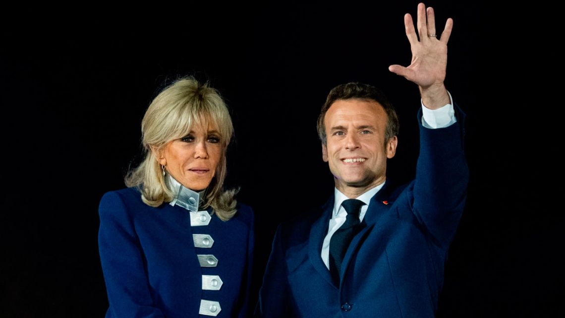 Emmanuel Macron, France's president, right, and wife Brigitte Macron celebrate on stage following the second round in the French presidential election, in Paris, France, on Sunday, April 24, 2022.