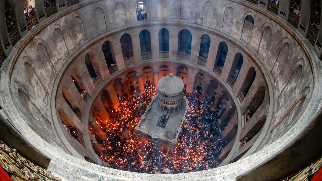 Los cristianos ortodoxos se reúnen con velas encendidas alrededor del Edículo, que tradicionalmente se cree que es el lugar de enterramiento de Jesucristo, durante la ceremonia del Fuego Sagrado en la iglesia del Santo Sepulcro de Jerusalén. | Foto:AHMAD GHARABLI / AFP