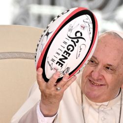 El Papa Francisco sostiene una pelota de rugby recibido como regalo del obispo francés Emmanuel Gobillard durante su audiencia general semanal en la plaza de San Pedro. | Foto:Tiziana Fabi / AFP