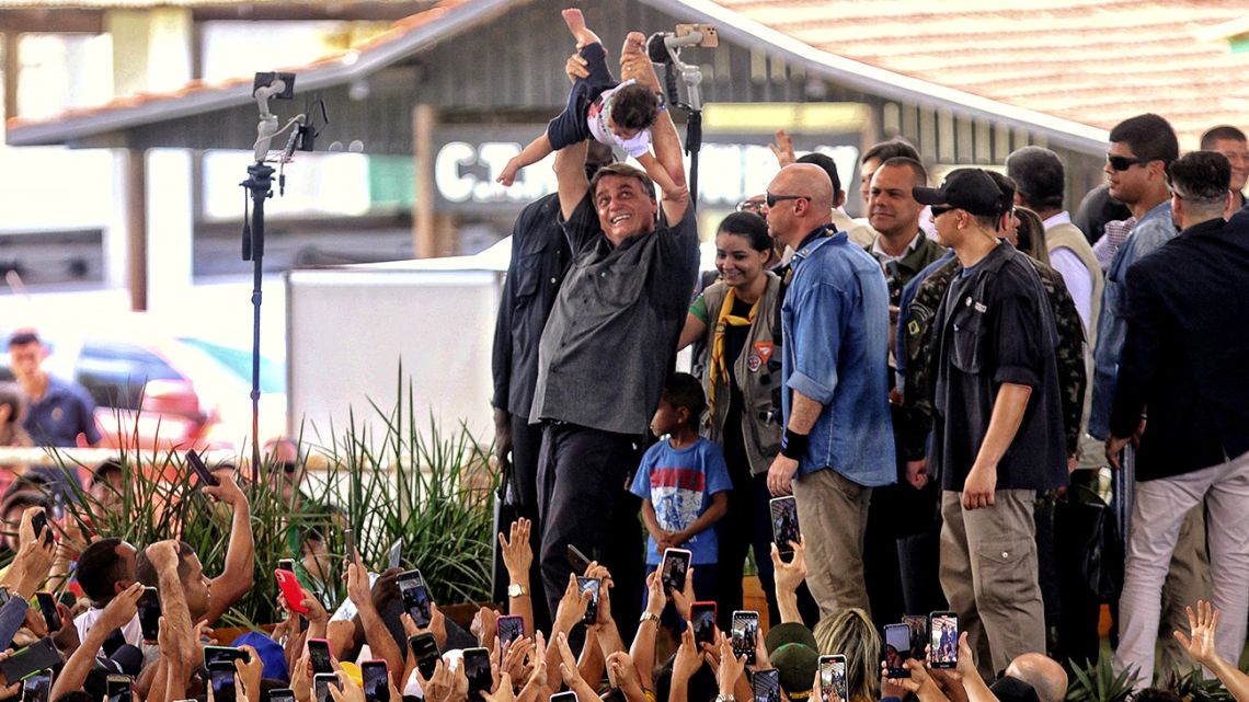 Brazil's President Jair Bolsonaro carries a toddler above his head during an event in which he was delivering land property titles at the city of Paragominas, Para state, Brazil on April 28, 2022.