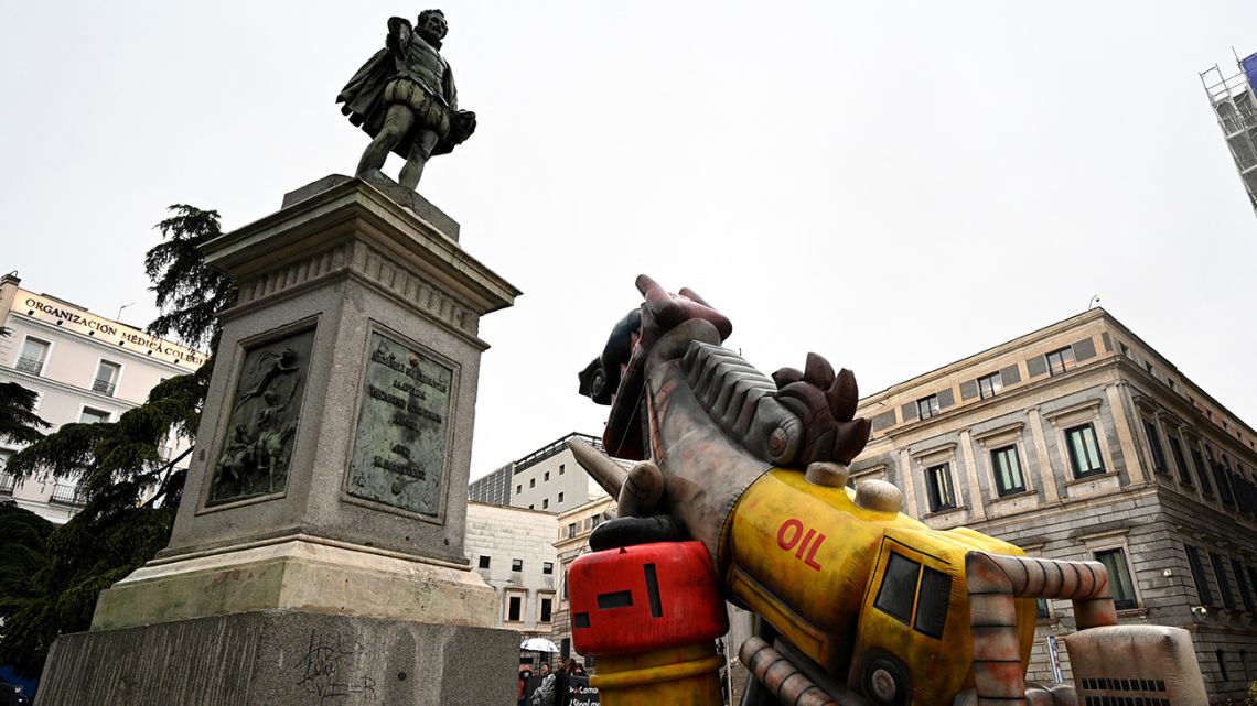 Members of "Ecologistas en Accion" (Ecologists in Action) install a giant inflatable dinosaur in front of the Spanish congress at Plaza de las Cortes in Madrid, on April 26, 2022, during a demonstration to call for an end to fossil fuels and a fair energy transition.