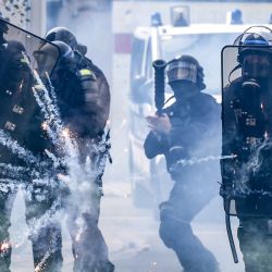 Agentes de la policía antidisturbios francesa se protegen de los fuegos artificiales lanzados por los manifestantes, al margen de la tradicional manifestación del Primero de Mayo en Nantes, oeste de Francia. | Foto:SEBASTIEN SALOM-GOMIS / AFP