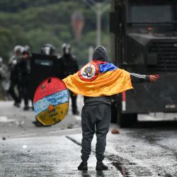 Un manifestante se enfrenta a la policía antidisturbios durante una protesta contra el gobierno del presidente colombiano Iván Duque con motivo del primer aniversario de un estallido social, en Medellín, Colombia. | Foto:Joaquín Sarmiento / AFP