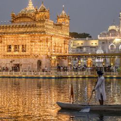 Un sij sewadar (voluntario) rema una barca en el sarovar sagrado o piscina sagrada con el telón de fondo del templo dorado iluminado en el aniversario del nacimiento de Guru Angad Dev Ji, el segundo gurú de los sikhs, en Amritsar, India. | Foto:NARINDER NANU / AFP