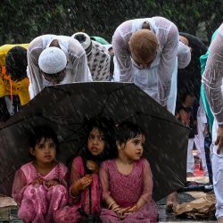 Los devotos musulmanes ofrecen oraciones especiales por la mañana en medio de una llovizna, para comenzar el festival Eid al-Fitr, que marca el final de su mes sagrado de ayuno del Ramadán, mientras llueve intensamente en la Red Road en Calcuta, India. | Foto:DIBYANGSHU SARKAR / AFP