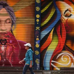 Una mujer camina frente a un mural, en Bogotá, Colombia. | Foto:Xinhua/Jhon Paz