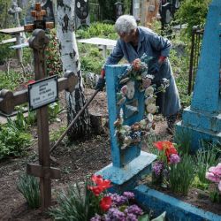 Valentyna, de 78 años, limpia alrededor de las tumbas de su madre e hija en el día del recuerdo, que marca una semana después de la Pascua ortodoxa, en Slovyansk, este de Ucrania, en medio de la invasión rusa de Ucrania. | Foto:YASUYOSHI CHIBA / AFP