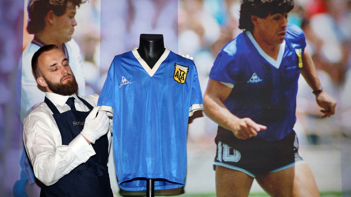 A Sotheby's technician adjusts a football shirt worn by Argentina's Diego Maradona during the 1986 World Cup quarter-final match against England, during a photocall at Sotheby's auction house in London. The shirt was auctioned for US$9.3 million, a record for any item of sports memorabilia, Sotheby's said May 4, 2022.