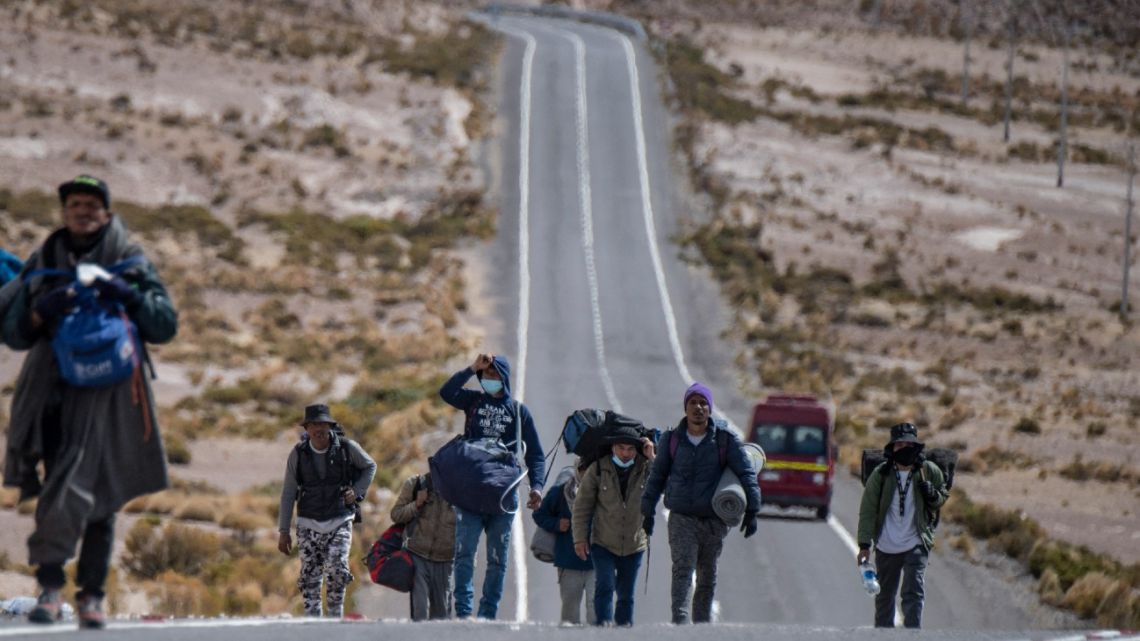 In this file photo taken on September 23, 2021, Venezuelan migrants walk towards Iquique from Colchane, Chile, after crossing from bordering Bolivia.