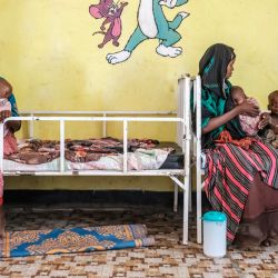 Mujeres y niños descansan en las camas de la unidad de nutrición del Centro de Salud de Kelafo, en la localidad de Kelafo, a 120 kilómetros de la ciudad de Gode (Etiopía). | Foto:EDUARDO SOTERAS / AFP