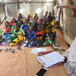 Alumnos sentados en su aula dentro de una tienda de campaña en un campo de desplazados internos en Ouallam, Nígeria. | Foto:Issouf Sanogo / AFP