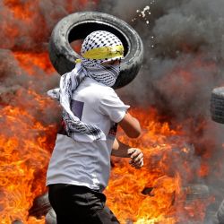 Manifestantes palestinos queman neumáticos en medio de enfrentamientos con las fuerzas de seguridad israelíes tras una manifestación contra la expropiación de tierras por parte de Israel, en el pueblo de Kfar Qaddum. | Foto:JAAFAR ASHTIYEH / AFP