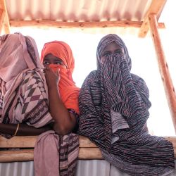 Unas mujeres observan mientras se asoman a una ventana en el campamento para desplazados internos de Farburo 2 en la aldea de Adlale, cerca de la ciudad de Gode, Etiopía. | Foto:EDUARDO SOTERAS / AFP