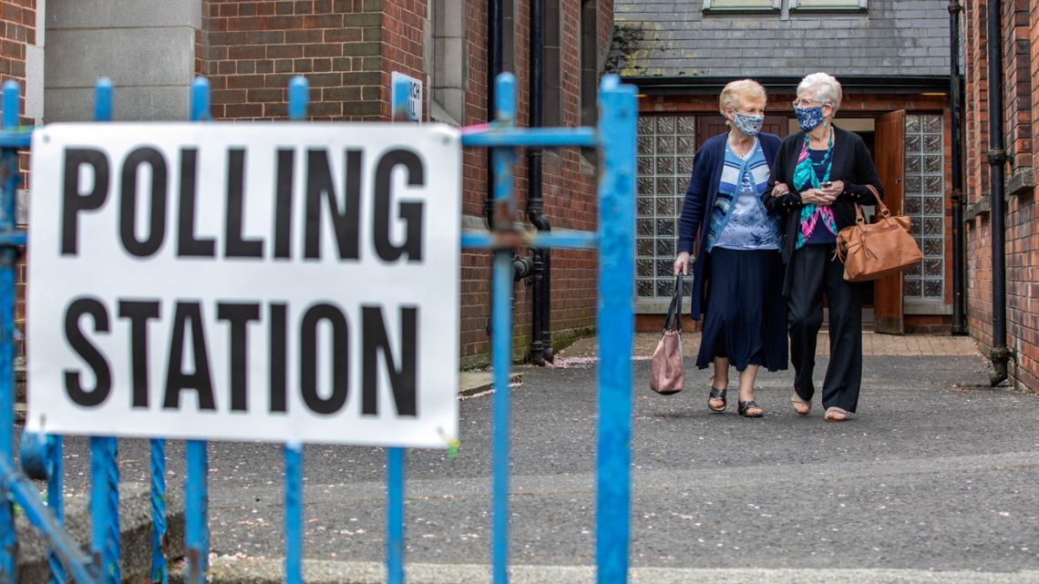 People leave a Polling station in North Belfast, after voting on May 5, 2022, as voting is underway to elect a new Assembly in Northern Ireland. 