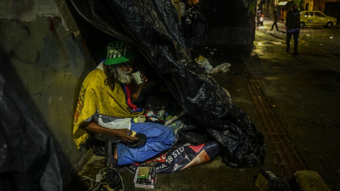 A homeless drug addict eats a meal delivered by volunteers in downtown Medellín, Colombia, on February 24, 2022.