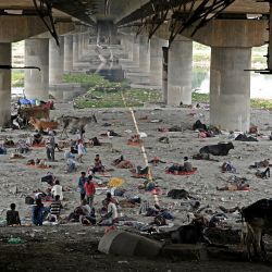 Personas sin hogar descansan bajo un puente para resguardarse del calor en una calurosa tarde de verano en Nueva Delhi, India. | Foto:Sajjad Hussain / AFP