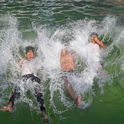 Unos chicos se refrescan en una piscina en un caluroso día de verano en Lahore, Pakistán. | Foto:ARIF ALI / AFP
