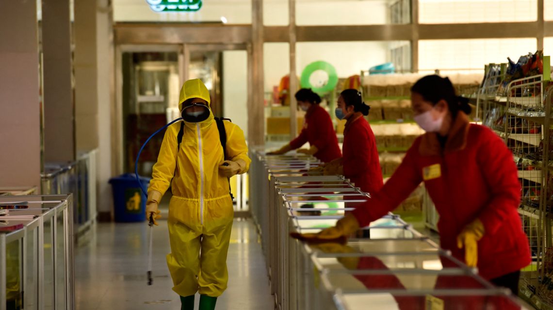 In this file photo taken on March 18, 2022, employees spray disinfectant and wipe surfaces as part of preventative measures against the Covid-19 coronavirus at the Pyongyang Children's Department Store in Pyongyan. 