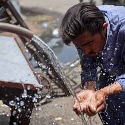Un peatón usa una tubería de agua para refrescarse en un caluroso día de verano en Karachi. Rizwan Tabassum / AFP | Foto:AFP
