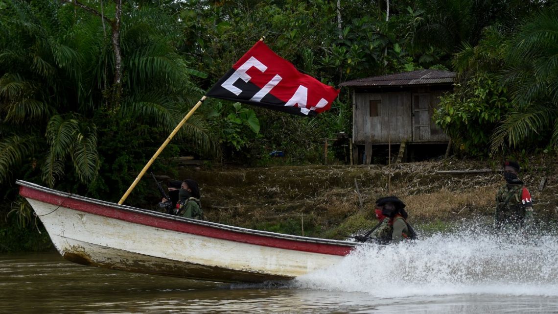 In this file photo taken on May 23, 2019, members belonging to the National Liberation Army (ELN) guerrillas patrol the river at the jungle, in Choco department in Colombia.