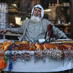 Un vendedor de rosarios se sienta dentro de  | Foto:AFP