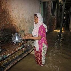 Una mujer cocina afuera de su casa en un corredor inundado luego de fuertes lluvias en Sylhet. Mamun HOSSAIN / AFP | Foto:AFP