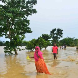 Los aldeanos caminan por un camino inundado después de las fuertes lluvias en el distrito de Hojai del estado indio de Assam . Biju BORO / AFP | Foto:AFP