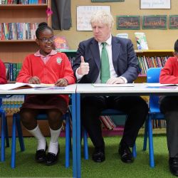 El primer ministro británico, Boris Johnson, se sienta en un pupitre con escolares durante una visita a la academia de primaria St Mary Cray, en el sureste de Londres, para ver cómo se imparten clases particulares para ayudar a los niños a ponerse al día tras la pandemia de Covid-19. | Foto:Stefan Rousseau / POOL / AFP