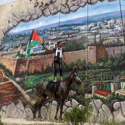Un jinete levanta una bandera palestina durante una manifestación organizada por la campaña internacional Retorno Palestino, en la ciudad libanesa de Kfar Kila, cerca del muro fronterizo con Israel. | Foto:MAHMOUD ZAYYAT / AFP