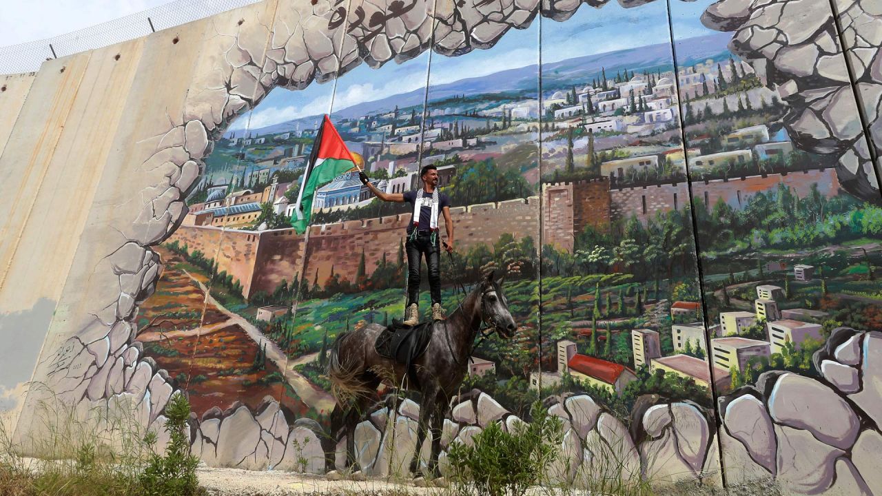 Un jinete levanta una bandera palestina durante una manifestación organizada por la campaña internacional Retorno Palestino, en la ciudad libanesa de Kfar Kila, cerca del muro fronterizo con Israel. | Foto:MAHMOUD ZAYYAT / AFP