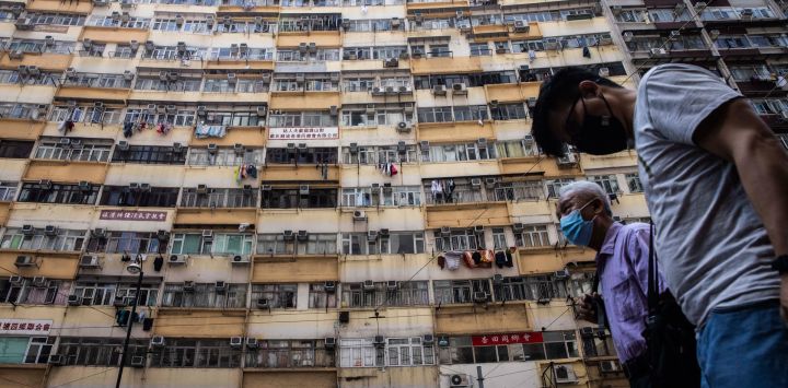 La gente pasa por delante de un bloque de apartamentos residenciales en Hong Kong.