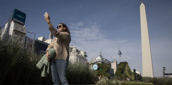 Una mujer se toma una fotografía frente al Obelisco, en la ciudad de Buenos Aires, Argentina. El Obelisco de Buenos Aires, inaugurado el 23 de mayo de 1936, y construido para celebrar los 400 años de la primera fundación la ciudad, celebra su 86 aniversario.