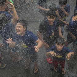 Los niños son rociados con agua mientras los devotos celebran la fiesta de Santa Rita de Cascia, patrona de las causas imposibles, en Baclaran, Manila. | Foto:JAM STA ROSA / AFP