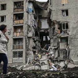 Una mujer camina junto a un edificio de apartamentos destruido en Bakhmut, en la región oriental ucraniana de Donbas, en medio de la invasión rusa de Ucrania. | Foto:ARIS MESSINIS / AFP