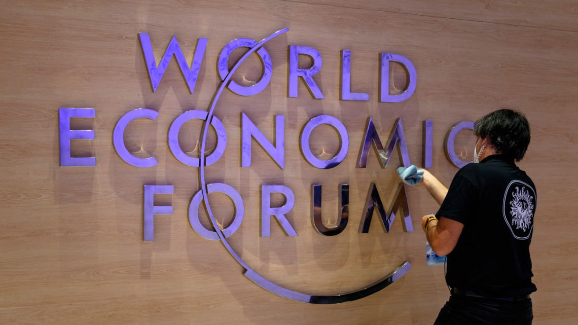 A worker cleans a sign of the logo of the World Economic Forum (WEF) inside the Congress centre ahead of the WEF annual meeting in Davos on May 22, 2022. 