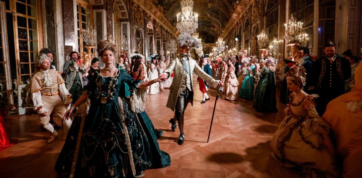 Invitados con trajes de estilo barroco caminan por el Salón de los Espejos del Palacio de Versalles en el marco de la sexta edición de la velada de disfraces Fetes Galantes, cuyo tema es la Boda Real de María Antonieta y Luis XVI, en Versalles.